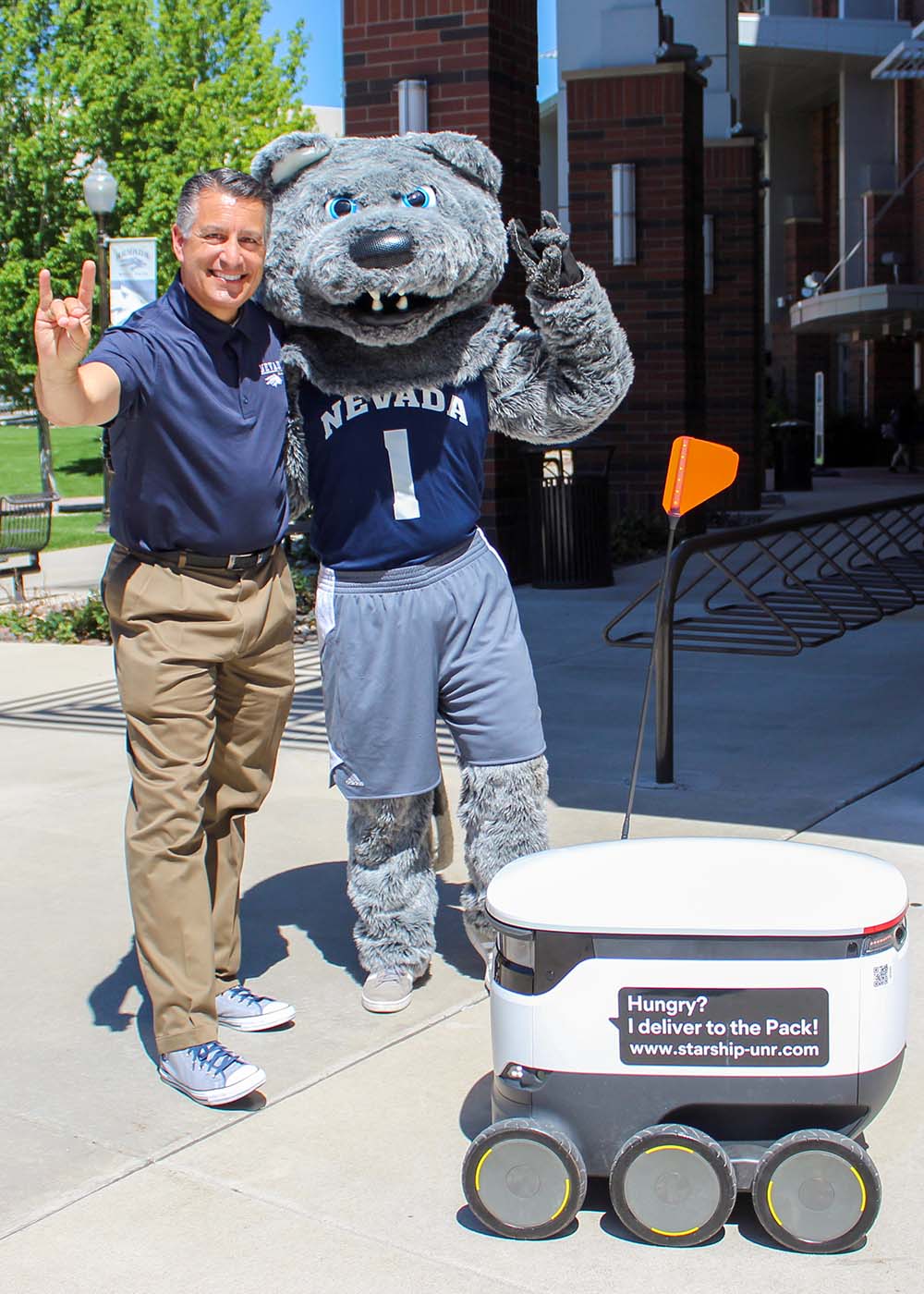 University of Nevada, Reno President Brian Sandoval with mascot Wolfie and a Starship food delivery robot.