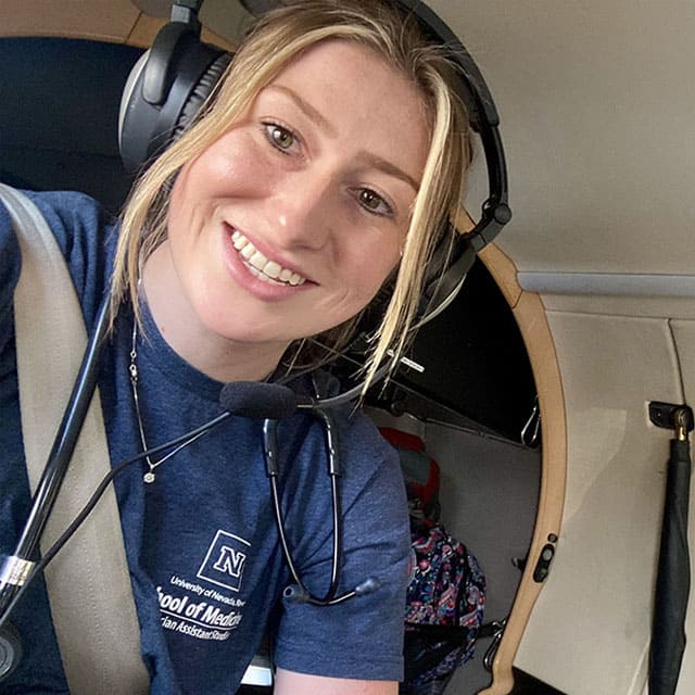 Maddie Schuster wears protective earphones while on a REACH fixed-wing aircraft transfer of an acutely ill patient from Ely, NV, to Las Vegas, NV.